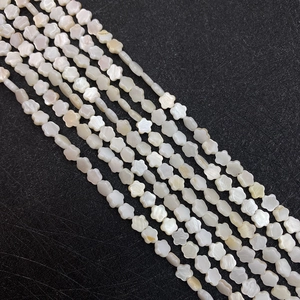 Macro shot of white shell beads in flower shape for DIY jewelry making and craft projects