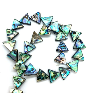 Détail macro de perles en nacre d'abalone triangulaires avec reflets irisés naturels