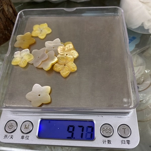 Primer plano de cuentas de concha talladas en forma de flor en tonos amarillos