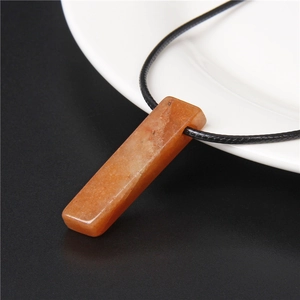 Detail eines rechteckigen orangefarbenen Edelsteinanhängers an einer schwarzen Kordel