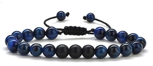 Macrodetail van herenarmband met tijgeroogkralen en verstelbaar zwart gevlochten koord