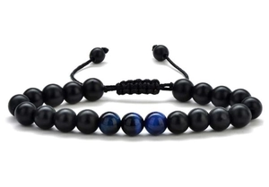 Macro-detail van herenarmband met matte zwarte kralen en blauwe tijgeroogstenen op de band