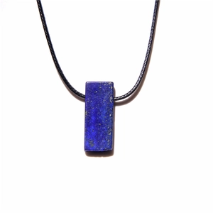 Detailaufnahme eines rechteckigen Lapislazuli-Anhängers mit goldfarbenem Pyrit und schwarzer Kordel