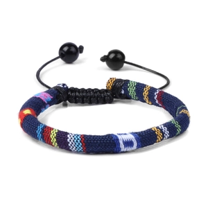 Detailed view of bohemian woven fabric bracelet with colorful stripes and adjustable cord
