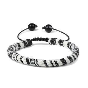 Close-up of bohemian hand-woven bracelet with black and white striped pattern and pull cord