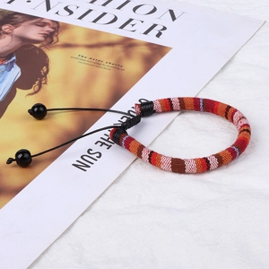 Detail of bohemian woven fabric bracelet with colorful stripes and adjustable beads