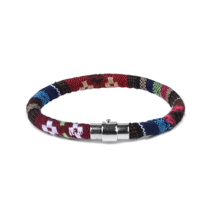 Detailopname van een bohemien gevlochten armband met kleurrijke patronen en magnetische sluiting