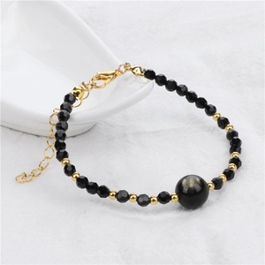 Detail van de 4mm gefacetteerde zwarte kralenarmband met gouden karabijnsluiting