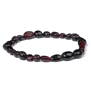 Macro detail of irregular deep red garnet beads with polished natural stone texture