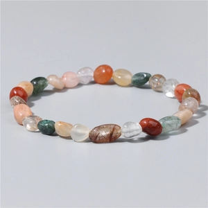 Macro detail of polished multi-color natural raw gemstones on an elastic bracelet