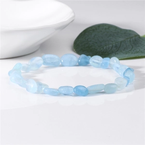 Detailed macro view of natural pale blue aquamarine stone beads on an elastic bracelet