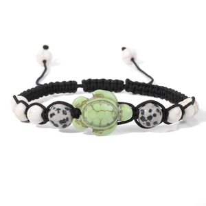 Detail of hand-woven turtle charm bracelet with marble beads and adjustable black cord