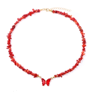 Detailed view of handmade necklace with irregular red stone beads and butterfly pendant