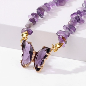 Macro detail of purple butterfly pendant with crushed crystal stone bead necklace