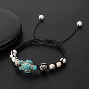 Detail of adjustable woven rope bracelet with natural stone beads and sea turtle charm
