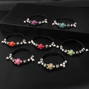 Detail view of seven colorful braided turtle bracelets with adjustable wax cords and beads