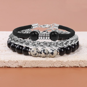 Dettaglio di un set di 3 bracciali da uomo con perline nere e catene in acciaio argentato