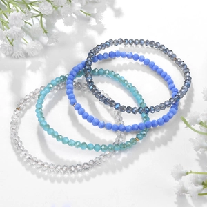 Detalle del conjunto de cuatro pulseras elásticas de cuentas de cristal azul y púrpura
