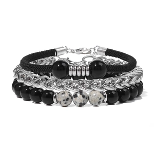 Dettaglio di un set di bracciali multistrato con perle nere opache e catena di metallo argento