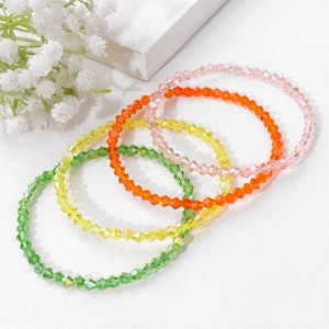 Macro detail of colorful faceted crystal bead bracelets in pink orange yellow and green set