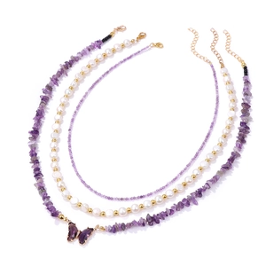 Detailed close-up of triple-layered necklace with purple stone beads and butterfly pendant