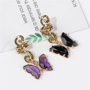 Détail macro de bijoux de cheveux papillon dorés avec cristaux violets et noirs