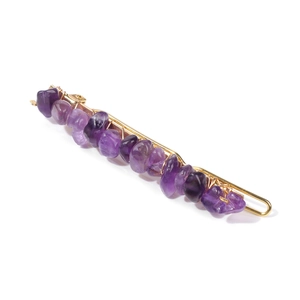 Detail view of purple crystal natural stones wrapped on a gold metal hair clip base