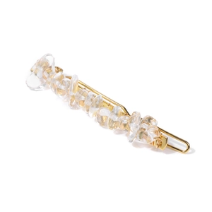 Macro shot of gold bobby pin with irregular transparent and yellow natural stones