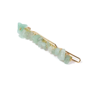 Detailed close-up of green natural stone hair clip with elegant gold wire wrapping
