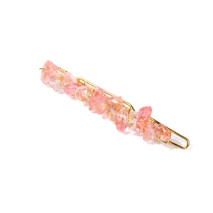 Detail view of pink and orange crystal stone hair clip with gold metal frame base