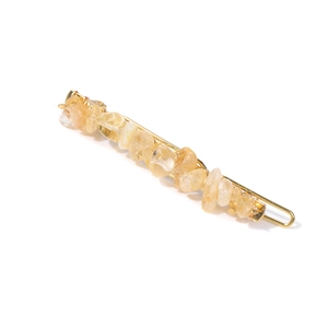 Detailed view of yellow natural stone hair clip with elegant golden metal base