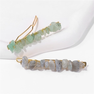 Detail of handmade hair clips with natural green and grey stones on gold metal base