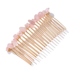 Detailed macro view of the golden metal hair comb with natural pink quartz stone chips