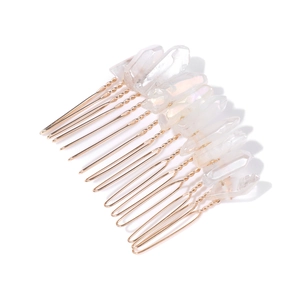 Macro detail of natural white crystal quartz clusters on a golden wire-wrapped hair comb