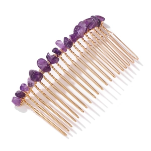 Detail of handmade gold wire wrapping purple natural stones on a 20-tooth hair comb
