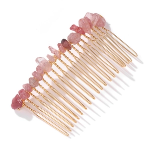 Close-up of golden hair comb with irregular pink natural crystal stone fragments