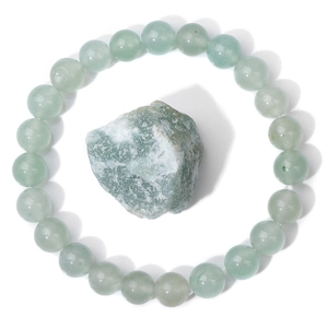 Detailed close-up of polished light green natural stone beads with a raw mineral piece