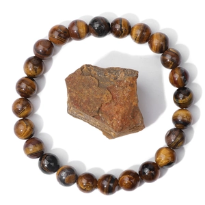 Macro view of polished tiger eye bead bracelet featuring golden silk luster and raw stone