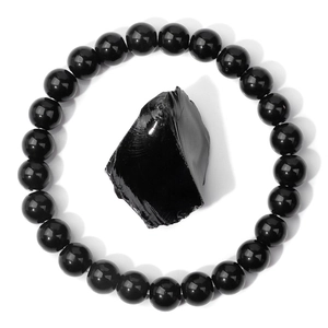 Macro detail of natural black obsidian stone bead bracelet with raw gemstone center