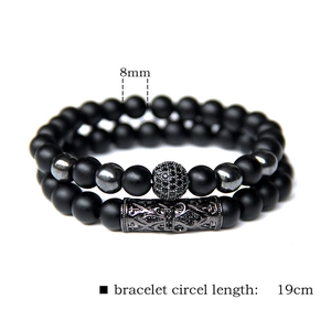 Detail of 8mm matte black stone bead bracelets with micro-pave skull and floral metal tube