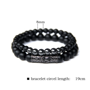 Detail view of 8mm black agate and hematite beads with carved metal cylinder ornament