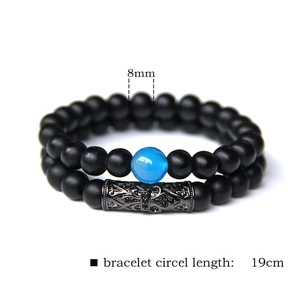 Detailed macro view of 8mm matte natural stone beaded bracelet with carved metal tube detail