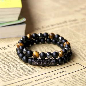 Detail of double-layer beaded bracelet with tiger eye stones and matte black onyx beads
