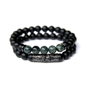 Detail view of double beaded bracelet set with matte black beads and green stone accents