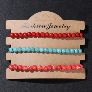 Close-up of three 4mm natural stone beaded bracelets on a fashion jewelry display card