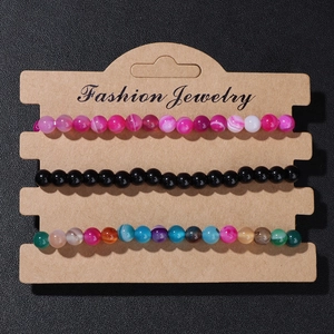 Detail view of 3-piece natural stone bead bracelet set on a kraft display card
