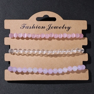 Detailed set of three 4mm natural stone elastic beaded bracelets on a kraft display card