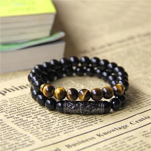 Detail of two-piece beaded bracelet set featuring tiger eye stones and a metal skull tube