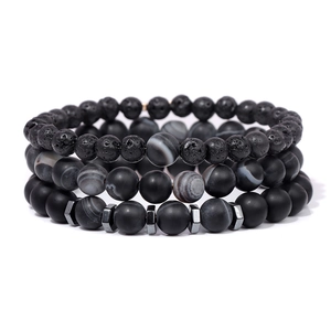 Detalle de cuentas de piedra de lava y ágata a rayas mate en un conjunto de pulsera de hombre