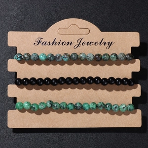 Detailed set of three 4mm natural stone elastic bracelets on a kraft display card